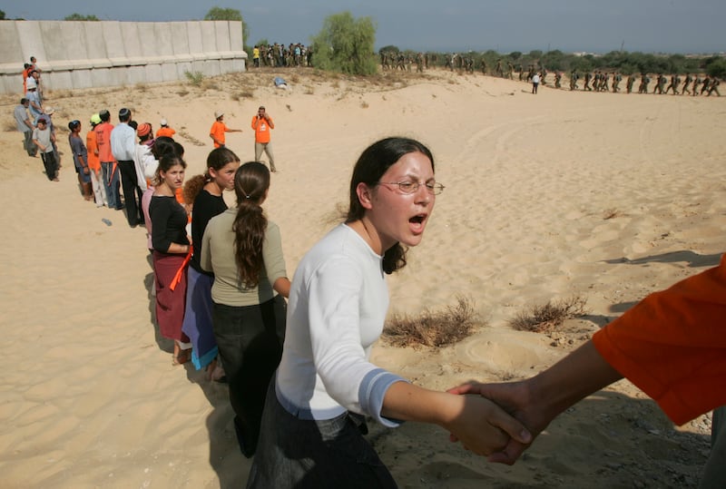 Supporters of the settler movement try to prevent soldiers from getting past them to houses in the settlement of Neve Dekalim in the Gaza Strip. Photograph: Ruth Fremson/The New York Times
                      