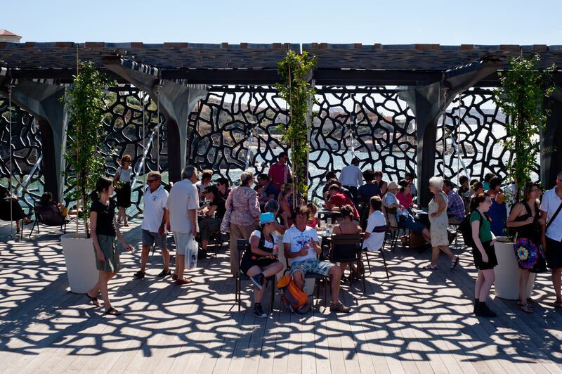 Visitors on the terrace of The Museum of European and Mediterranean Civilizations (MuCEM) in Marseille. The building is surrounded by a  latticework shell of fibre-reinforced concrete.