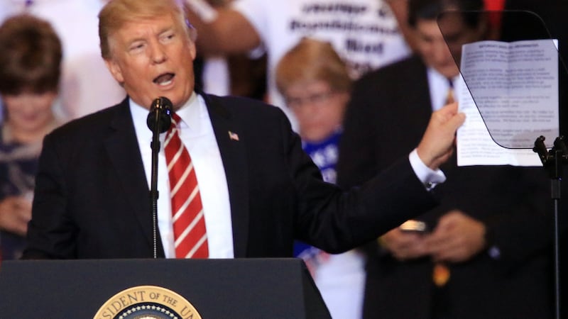 US president Donald Trump shows speeches from the past week as he addresses the crowd during a campaign rally in Phoenix, Arizona. Photograph: Roy Dabner/EPA