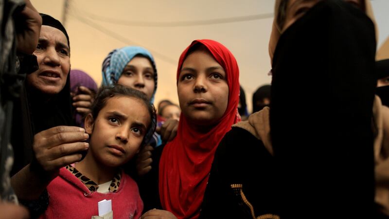 Displaced people gather to complain about the lack of food supplies outside a processing centre as smoke from a burning oil refinery blankets Qayyara, south of Mosul, Iraq. Photograph: Zohra Bensemra/Reuters