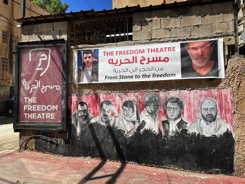 A banner shows photographs of the founders of the Freedom Theatre in Jenin: Zakaria Zubeidi, who has been detained in an Israeli prison without trial since 2019, and Juliano Mer Khamis, who was murdered by an unknown assailant in 2011. Photograph: Hannah McCarthy