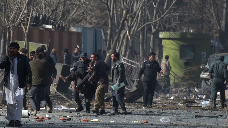 Afghan volunteers and policemen help the wounded at the scene of a car bomb in Kabul. Photograph: AFP