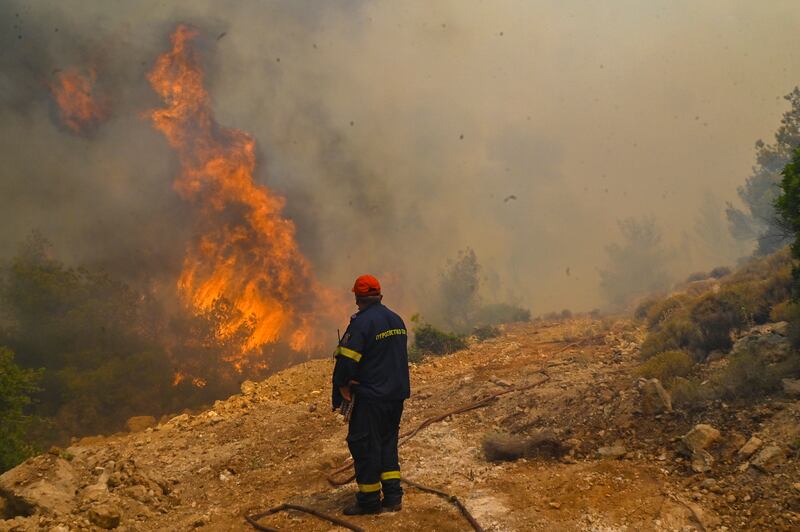 A firefighter runs so not to be surrounded by fire as he tries to extinguish a wildfire burning near the village Vlyhada near Athens on Wednesday. Photograph: Milos Bicanski/Getty