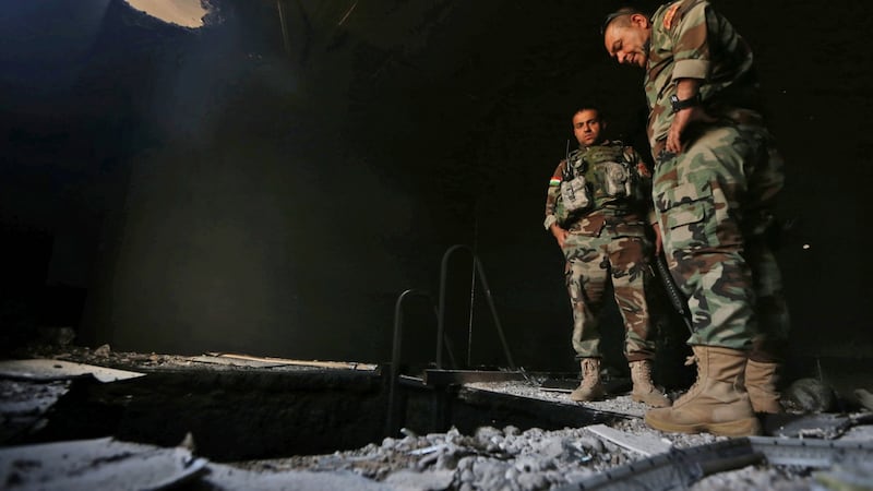 Kurdish Peshmerga forces inspect a tunnel in  a building in  Shaqouli village, about 35km east of Mosul, on Tuesday, after they had recaptured it from  Islamic State Photograph: Safin Hamed/AFP/Getty Images