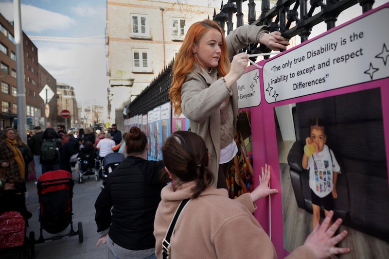 Skye-Lyn Devignat from Balbriggan puts up a poster outside the Department of Education to highlight the need for school places for children with additional needs. Photograph: Chris Maddaloni