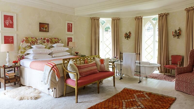 Castle bedroom. Cath got inspiration for the castle bedroom from a collection of photographs and prints of pink and red rooms. Pinned over the headboard is a printed cotton from Pondicherry. Photograph: by Christopher Simon Sykes.