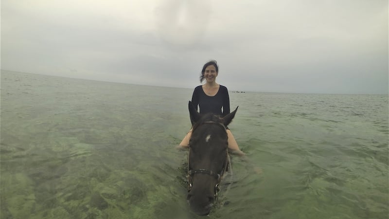 Emma on Chocolate Chip in the sea at Grand Cayman. Photograph: Melanie May