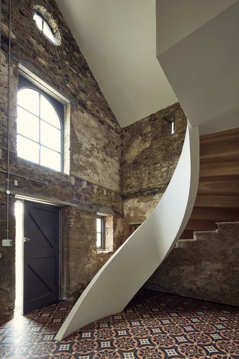 The coach house’s unplastered walls contrast with the sculptural sweep of the concrete ribbon stairs and its timber cantilevered steps.