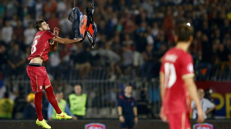 Stefan Mitrovic of Serbia grabs a flag depicting so-called Greater Albania that was flown from a mini drone over the pitch during their Euro 2016 Group I qualifier against Albania at the FK Partizan stadium in Belgrade. The politically-sensitive game  was abandoned following a brawl between players from both sides after the flag stunt. Photograph: Marko Djurica/Reuters