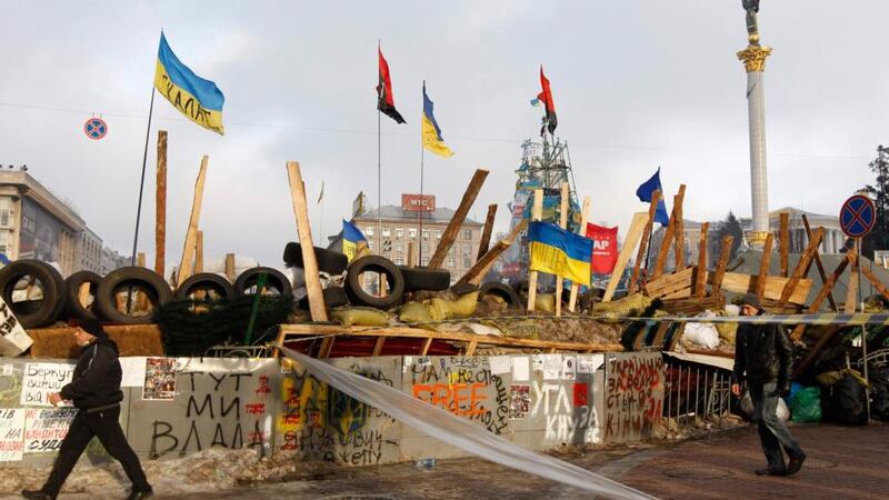 People pass by a barricade erected by Pro-European integration protestors in central Kiev today. UPresident Viktor Yanukovich said he would propose an amnesty for those detained at recent mass street protests, a key demand of opposition leaders. Photograph: Vasily Fedosenko/Reuters