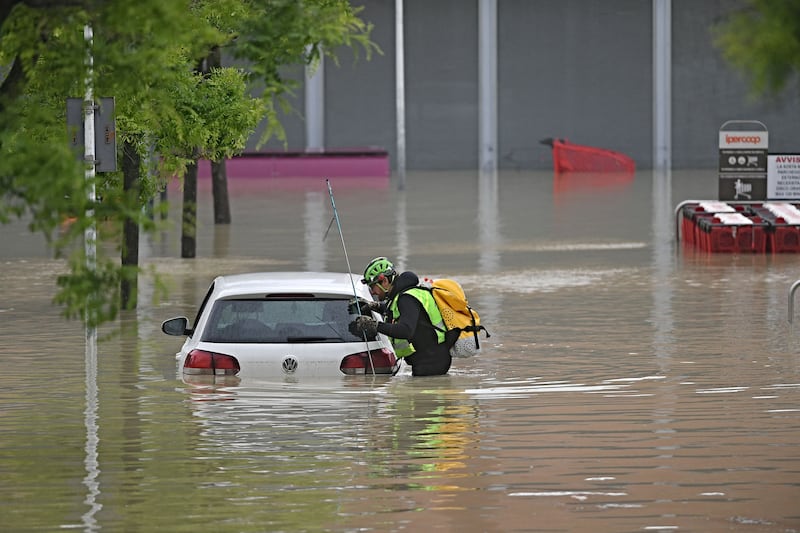 An alpine rescuer looks in a car for missing persons near a supermarket in a flooded area in Cesena on Wednesday. Photograph: Alessandro Serrano/AFP via Getty Images