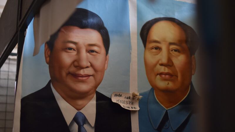 Painted portraits of Chinese President Xi Jinping (left) and late communist leader Mao Zedong at a market in Beijing. Photograph: Greg Baker/AFP/Getty Images