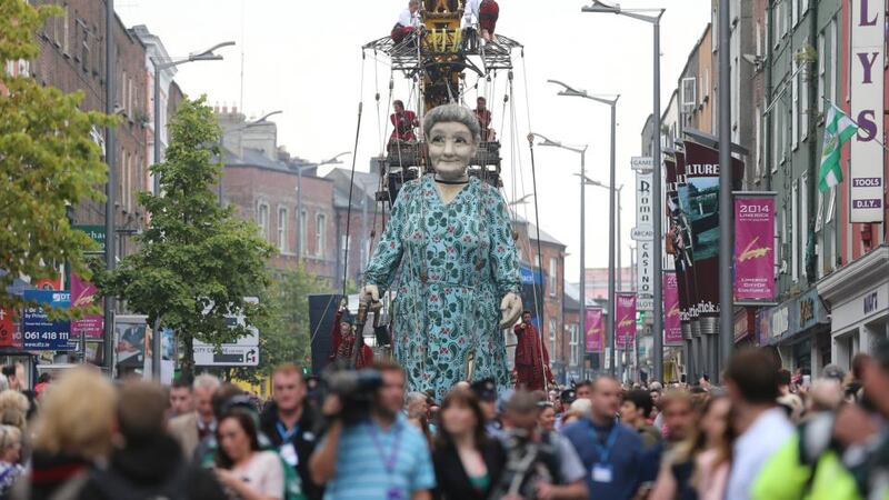 Crowds watch as performers from the French arts group Royal de Luxe take to the streets of Limerick with their Giant Grandmother parade as part of this years city of culture celebrations. Photograph: Niall Carson/PA Wire.