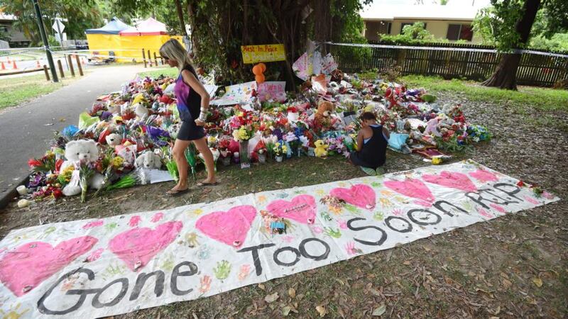 Mourners attend a floral tribute near a house in which eight children were stabbed to death in the Cairns suburb of Manoora, Australia, on Sunday. Photograph: EPA