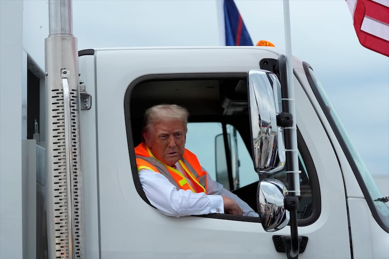 Donald Trump talks to reporters as he sits in a garbage truck Photograph: Julia Demaree Nikhinson/AP