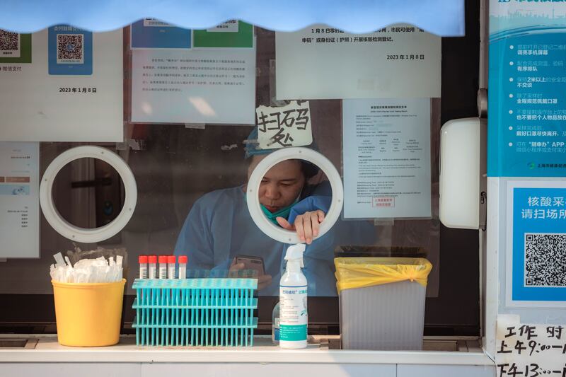 A woman sits in one of the few remaining Covid-19 testing booths, in Shanghai, China. Photograph: Alex Plavevski/EPA