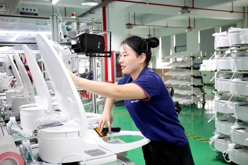 An employee working on the assembly line, making ‘intelligent toilets’ at a factory in Hangzhou, east China. Photograph: Xu Junyong/VCG/Getty Images