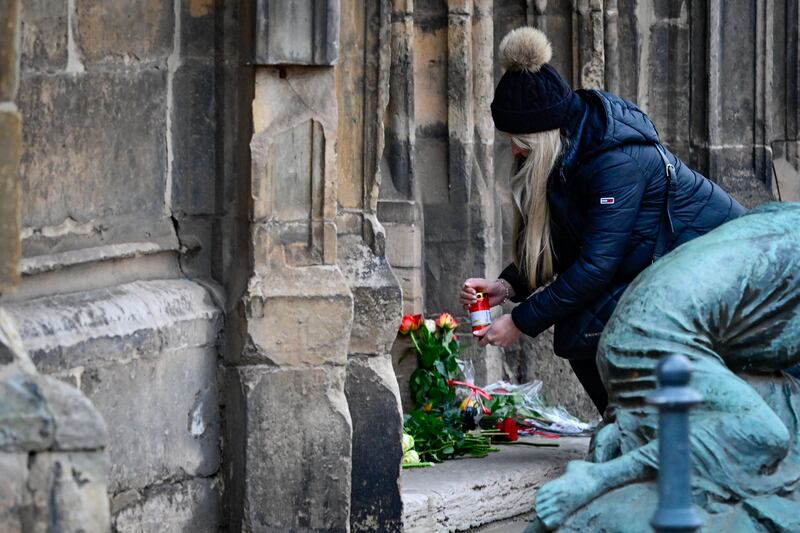 A‍ mourner lights a candle​ near the Christmas market. Photograph: John Macdougall/AFP/Getty