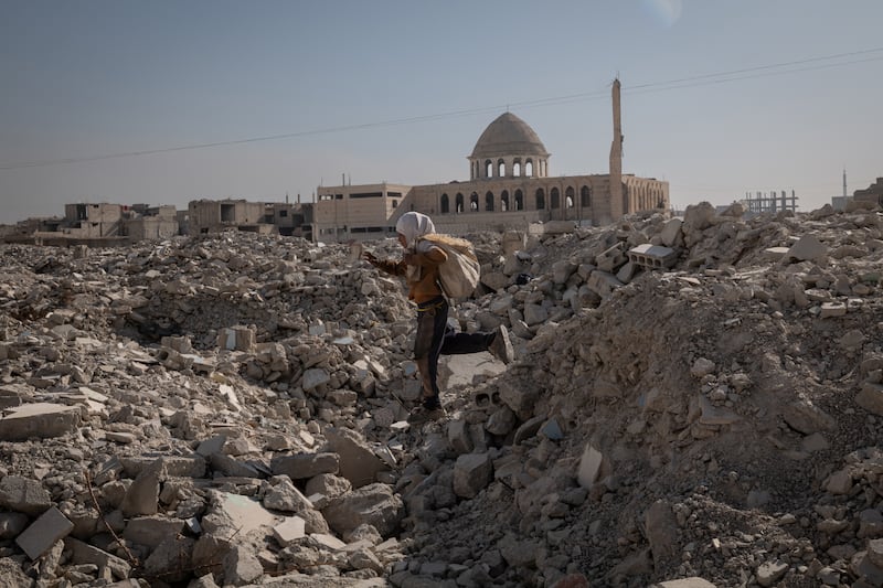 A child looks for scrap metal and plastics in a destroyed area of the Tadamon neighborhood in Damascus, Syria, on December 16th. Photograph: Nicole Tung/The New York Times 