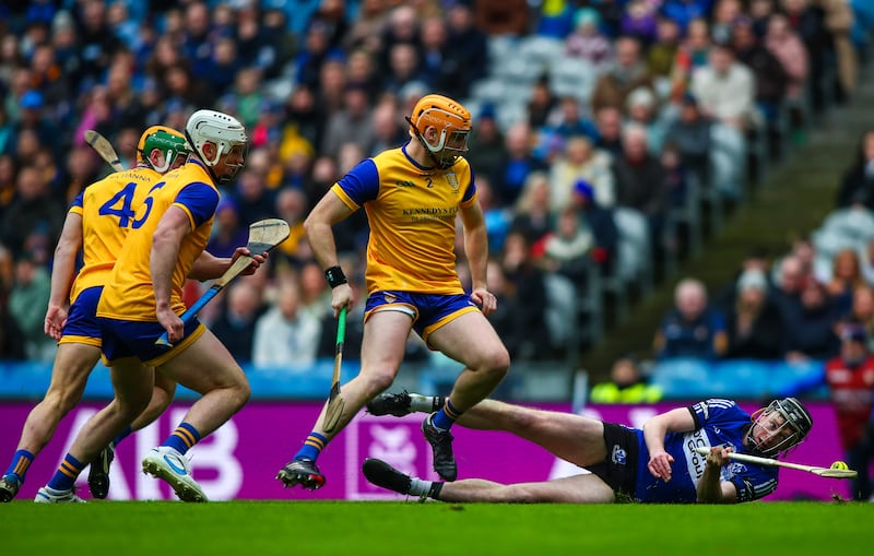 Sarsfields’ Jack O'Connor tries to gather possession after being tackled by Na Fianna's Sean Burke. Photograph: Ken Sutton/Inpho