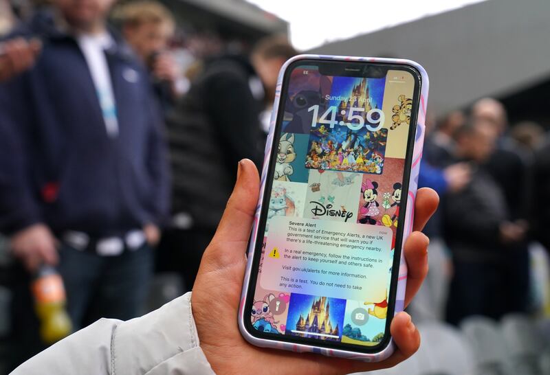 An emergency text alert test on the phone of another fan during the Premier League match. Photograph: Owen Humphreys/PA