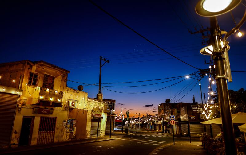 A view of an empty street with closed shops at sunset in Ashkelon, southern Israel, near the Gaza border, on Friday evening. Photograph: Hannibal Hanschke/EPA