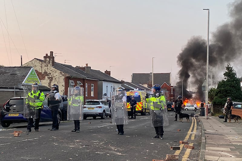 Smoke billows from a fire started by protesters as riot police stand guard after disturbances near the Southport Islamic Society Mosque in Southport, northwest England, on July 30th. Photograph: Roland Lloyd Parry/AFP via Getty Images