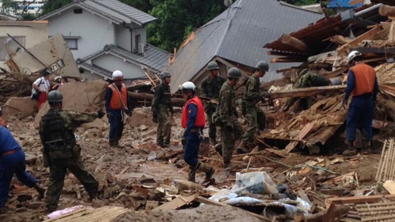 Japan self-defence force soldiers and rescue workers search for survivors as a site where a landslide swept through a residential area at Asaminami ward in Hiroshima, western Japan. Photograph: Joint Staff of the Defence Ministry of Japan/Handout via Reuters.