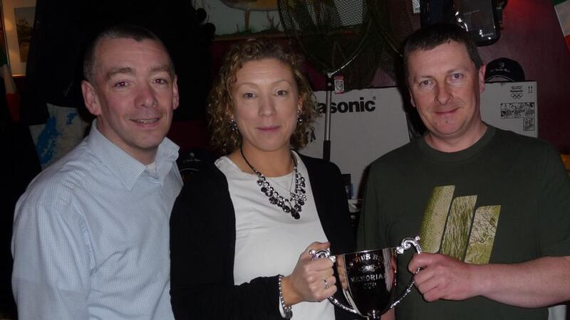 Malcolm Naughton (Loughrea, right), taking the Ignatius Burke Memorial Cup from his children, John and June Burke, after the open fly-fishing competition at Clonbur