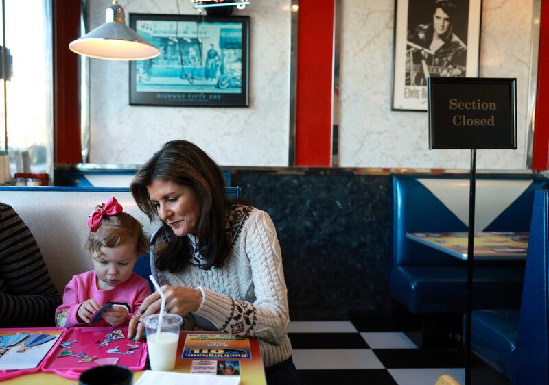  Republican presidential candidate with Bristol Teal (2), who was having breakfast with her parents at Mary Ann's diner on Sunday in Derry, New Hampshire.  Photograph: Joe Raedle/Getty Images