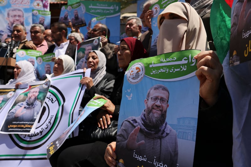 People hold portraits of Khader Adnan during a rally in Gaza city following the announcement of his death. Photograph: Mohammed Abed/AFP via Getty Images