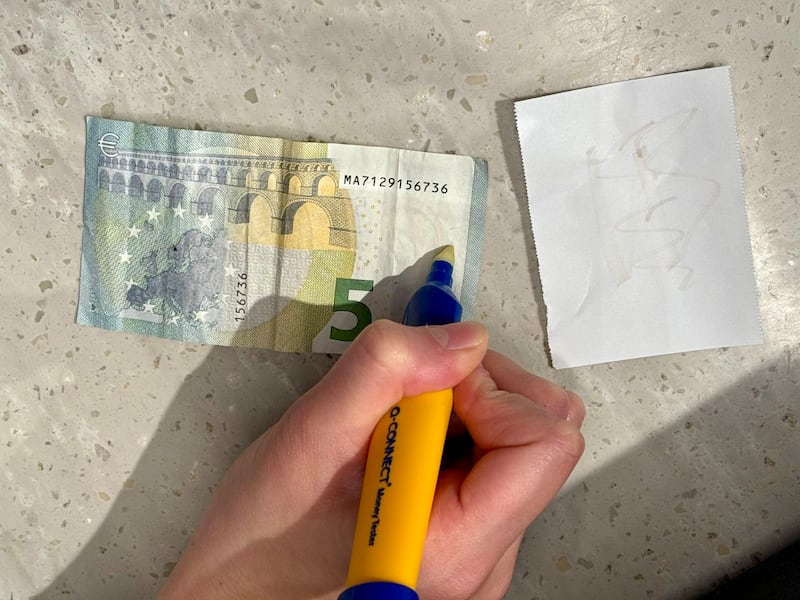 Counterfeit money identifier used in genuine notes becomes transparent. Photo by Alekson Lacerda. For article on counterfeit currency November 2024