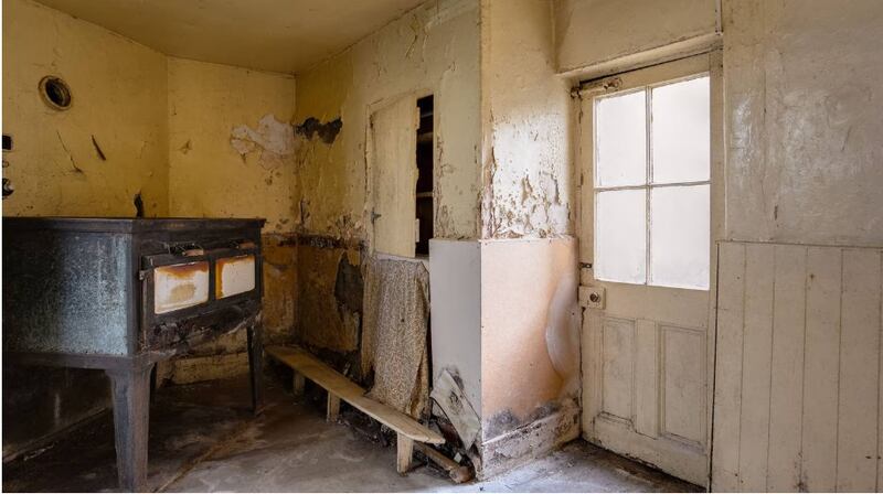 Pre-renovation interior of Bennett’s Bakery, showing the original oven, not included in the sale, and the back door to very small courtyard