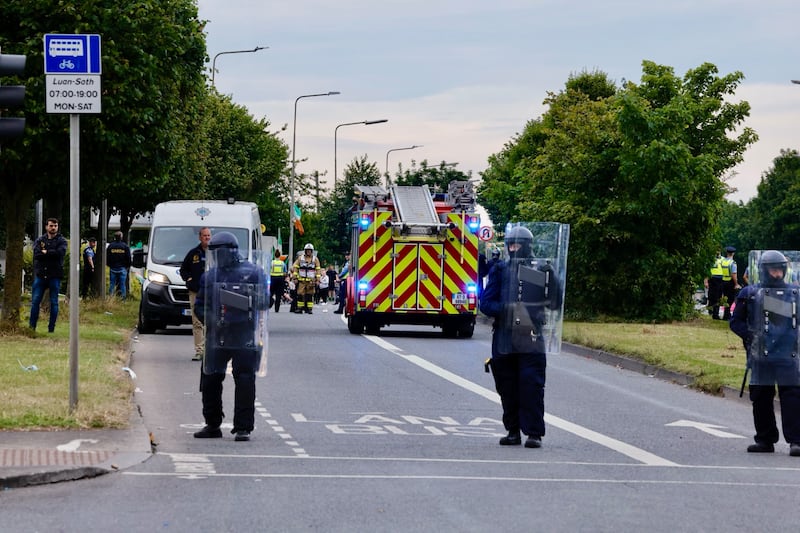 Gardaí clear protestors to allow the fire brigade to tend to a small fire at the former Crown Paints factor in Coolock, north Dublin following a protest at the proposed housing of international protection applicants in July. Photograph: Alan Betson