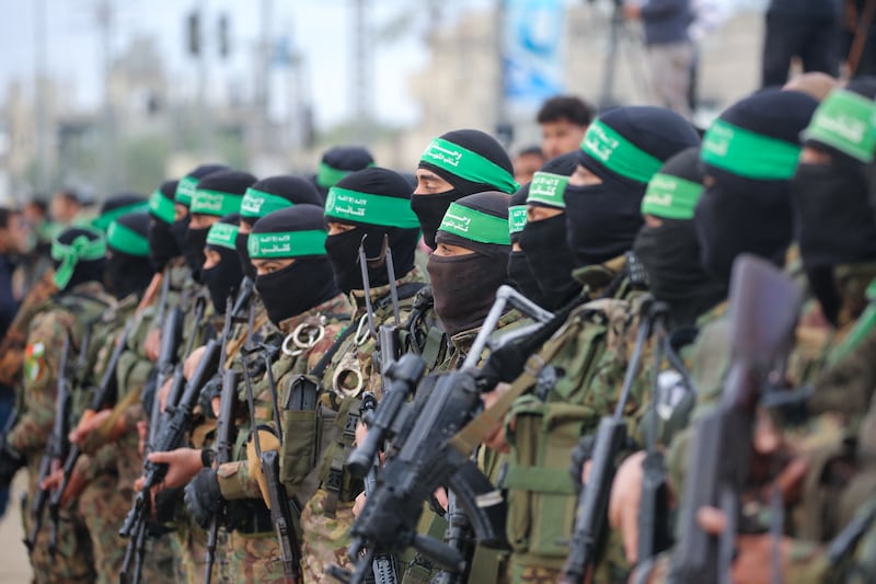 Hamas fighters secured areas before handing over three Israeli hostages to a Red Cross team in Deir el-Balah, central Gaza. Photograph:  Eyad Baba/AFP