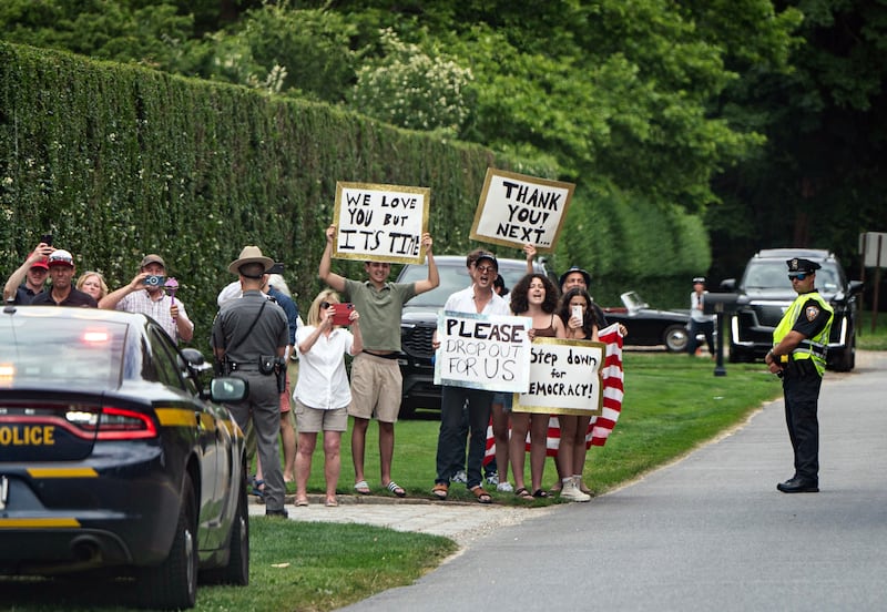 People in East Hampton, New York, hold signs calling for Joe Biden to step aside from November's election as a motorcade carrying the US president and first lady Jill Biden goes by. Photograph: Haiyun Jiang/New York Times
                      