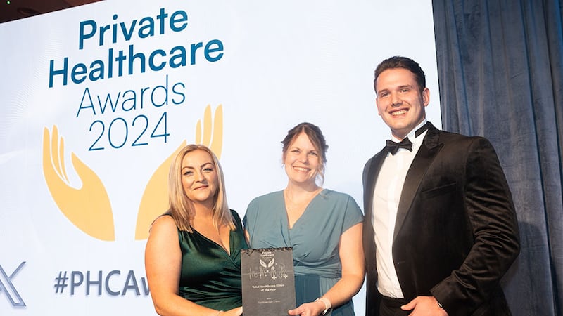 Lara Kane, managing director of Medforce, presents the total healthcare clinic of the year award to Joanna Melia and Reid Gardiner, Optilase Eye Clinic