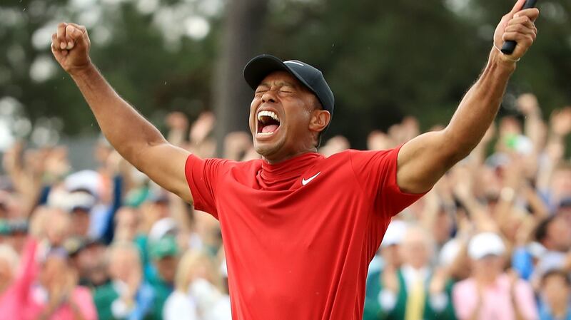 Tiger Woods celebrates after sinking his putt on the 18th green to win the Masters at Augusta National. Photograph:  Andrew Redington/Getty