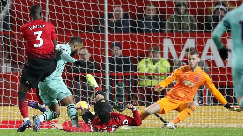 Eric Bailly’s tackle on Alexandre Lacazette sends the ball past David de Gea. Photo: Martin Rickett/PA Wire