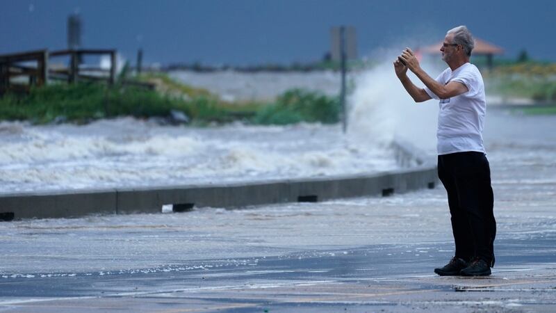 A spectator photographs the flood waters at the Port Gulfport Marina as they watch the arrival of Hurricane Ida Sunday, in Gulfport, Mississippi. Photograph: Steve Helber/AP