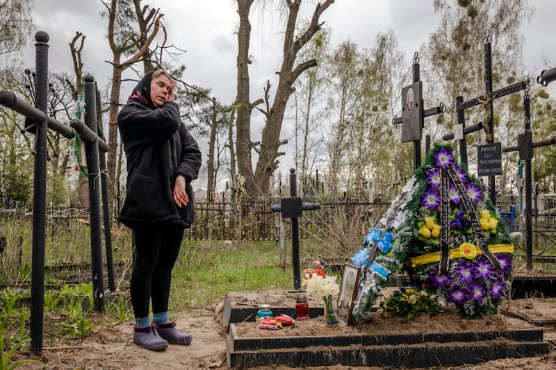 Iryna Abramova visits the grave of her husband, Oleh Abramov, in Bucha, Ukraine, in April 2022. Photograph: Daniel Berehulak/New York Times