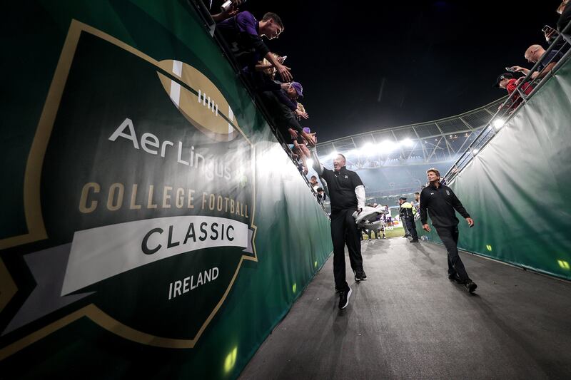 Northwestern Wildcats head coach Pat Fitzgerald celebrates with fans as he leaves the pitch at the Aviva Stadium.  Photograph: Laszlo Geczo/Inpho