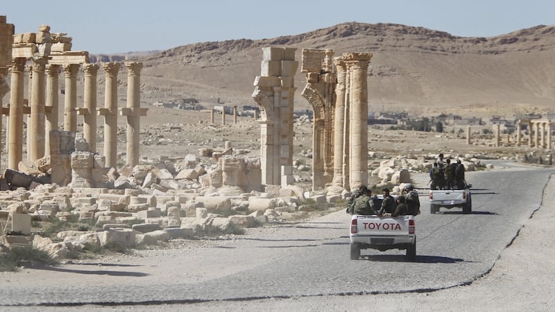 Syrian army soldiers drive past the Arch of Triumph in the historic city of Palmyra in this April 2016 Reuters file photograph.