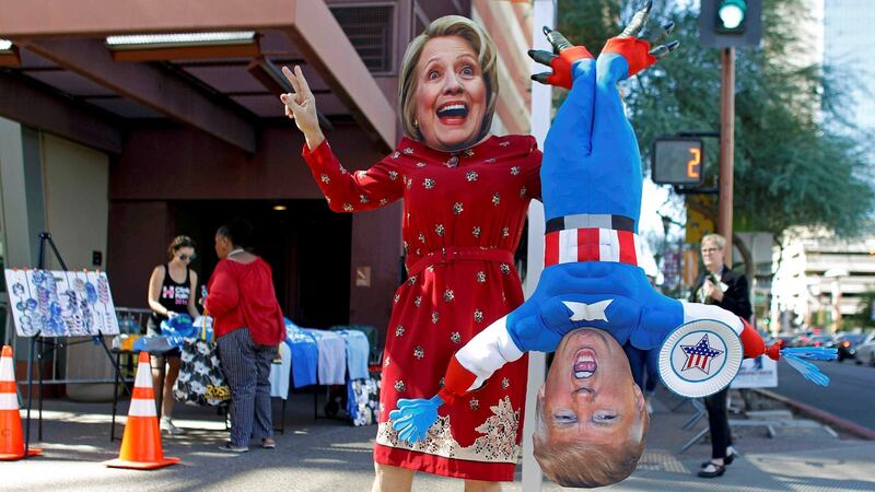 A man wears a mask depicting Democratic US presidential candidate Hillary Clinton while holding a doll depicting Republican  nominee Donald Trump in Phoenix, Arizona, on October 2th. Photograph: Ricardo Arduengo/Reuters