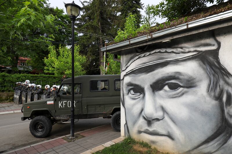 Peacekeeping soldiers guard a street near graffiti depicting former Bosnian Serb wartime general Ratko Mladic, in the town of Zvecan, northern Kosovo. Photograph: AP