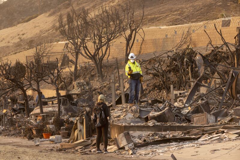 LA fires: Residents look through their burned home in the Pacific Palisades area of Los Angeles, California. Photograph: Jill Connelly/Bloomberg