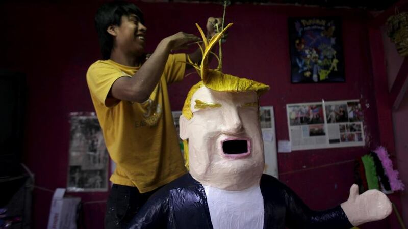 A worker hangs a paper mache figure depicting Republican presidential candidate Donald Trump at a workshop in Reynosa, Mexico, Angry Mexicans can beat it with a stick. Photograph: Reuters/Daniel Becerril