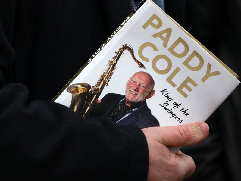 A mourner carries Paddy Cole's autobiography at the musician's funeral at St Mary's Church, Castleblaney, Co Monaghan. Photograph: Colin Keegan/Collins