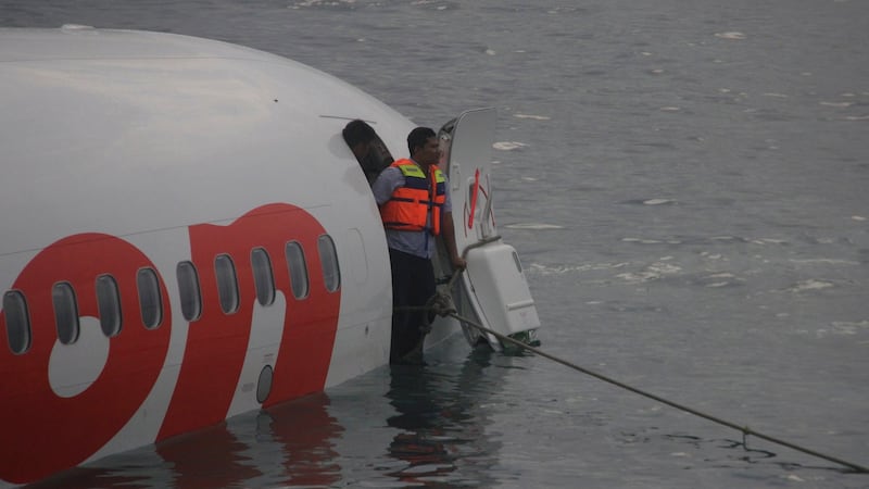 A rescue worker stands at the door of the Lion Air plane. Photograph: Reuters/Indonesian Police Handout.