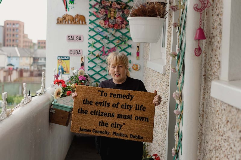 A woman shows one of Augustine O'Donoghue's political door mats